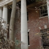 <p><strong>Neoclassical, details</strong>: Doric design elements, plain columns, and elaborated doorway, Administration Building (Building 13), center pavilion, or portico. East facade, view northwest, November 2005.</p>